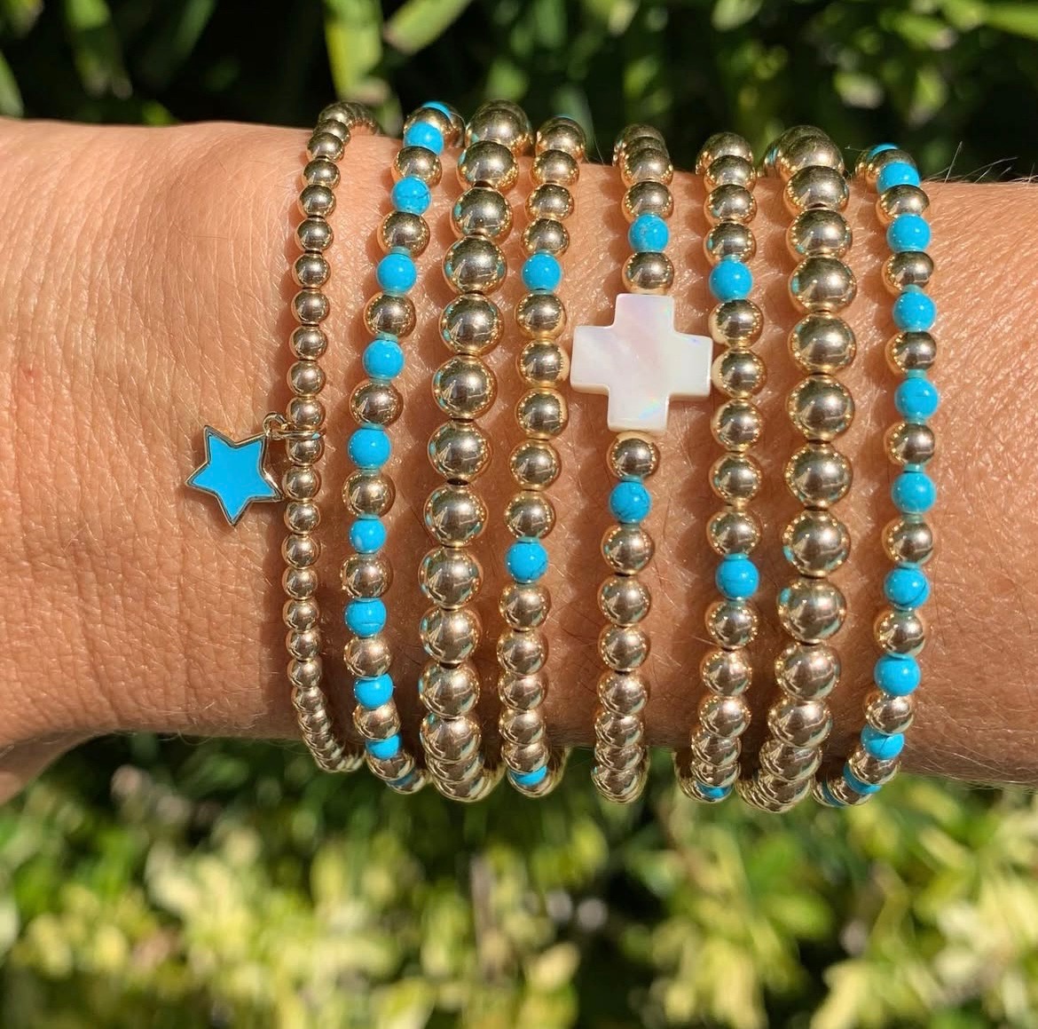 Gold bead bracelets accented with turquoise stars and crosses